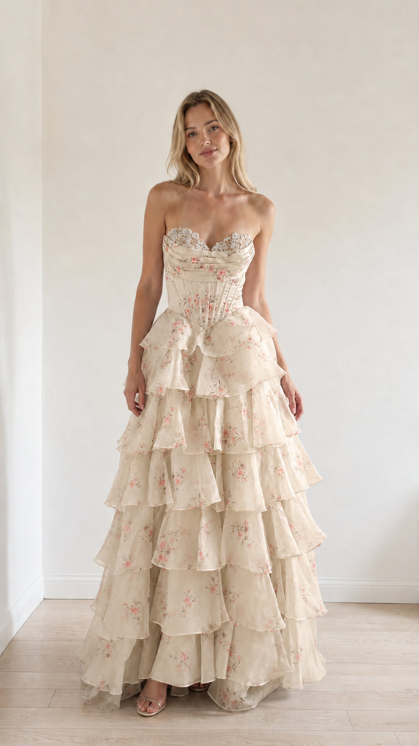 Model wearing champagne floral tiered ruffle strapless evening gown