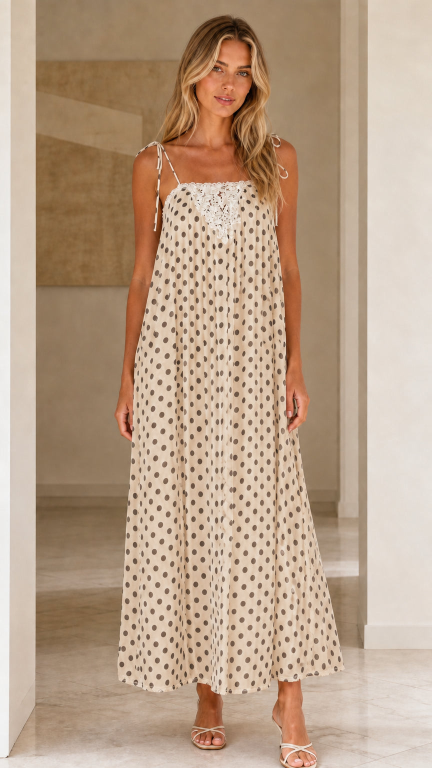 Front view of woman wearing beige polka dot maxi dress