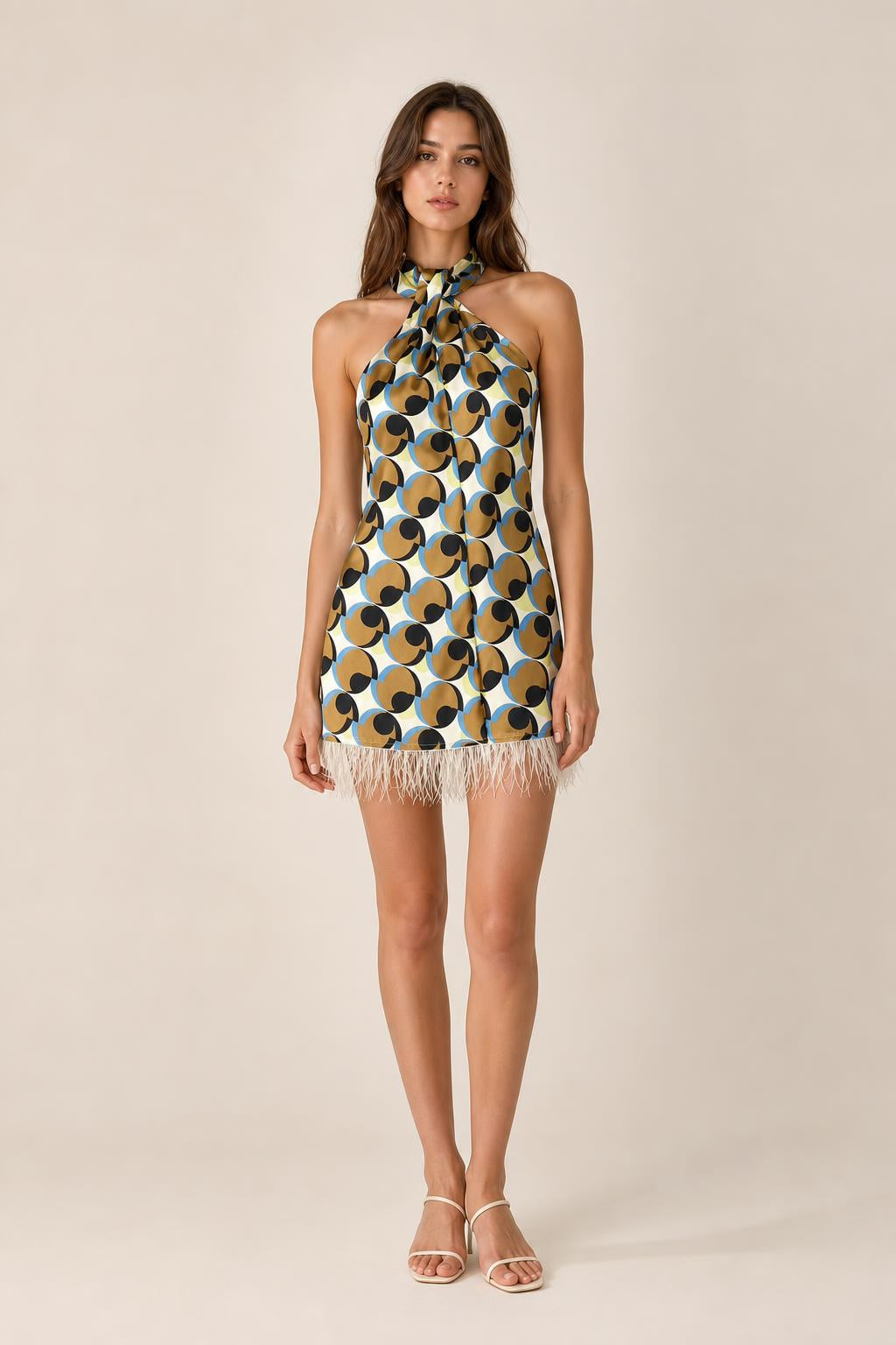 Front view of model wearing geometric halter mini dress with feather hem