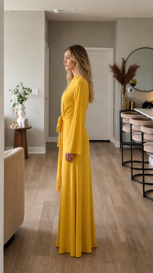 Side profile of model in yellow wrap dress with tie belt