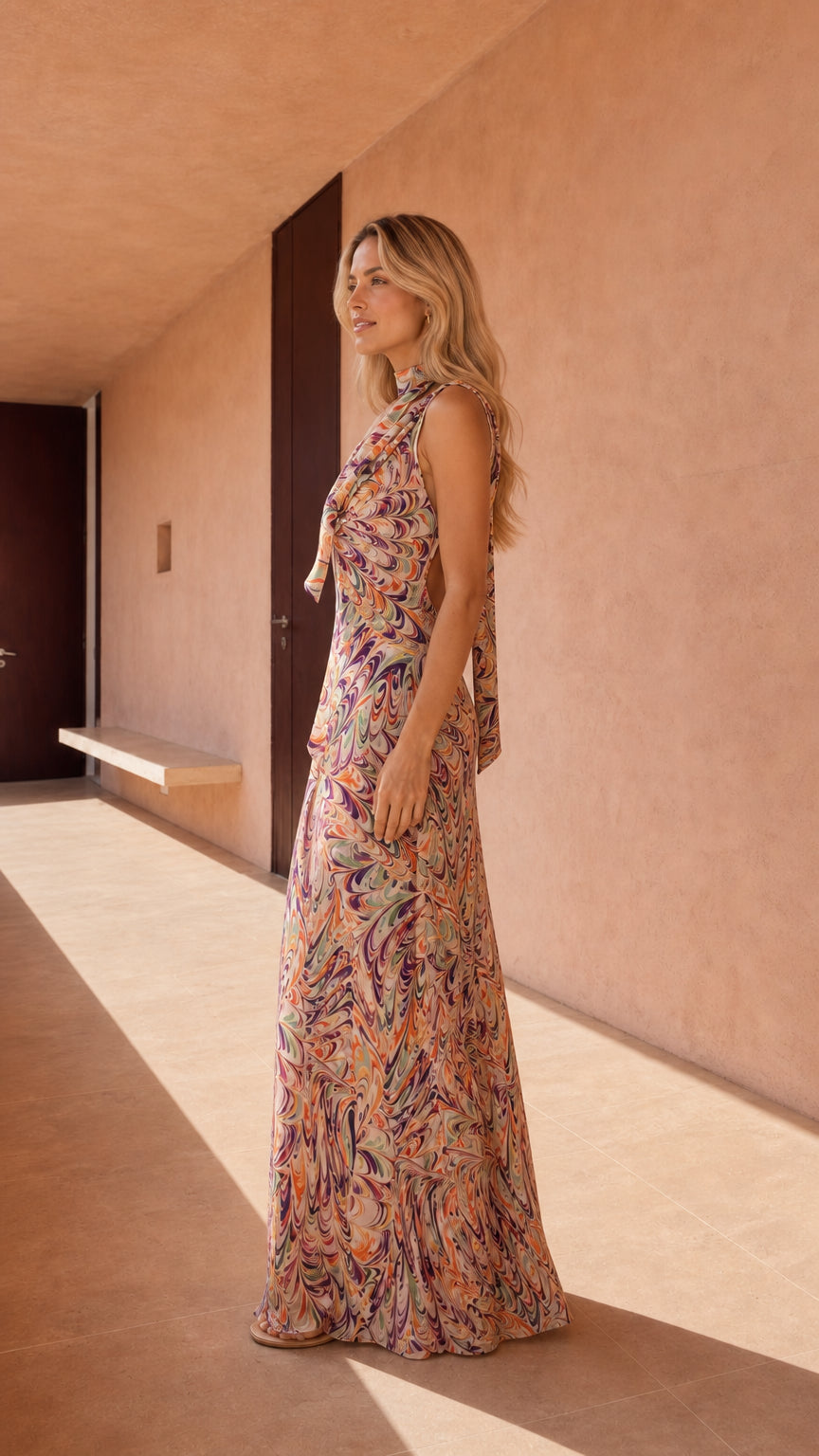 Side profile of model in abstract print maxi dress