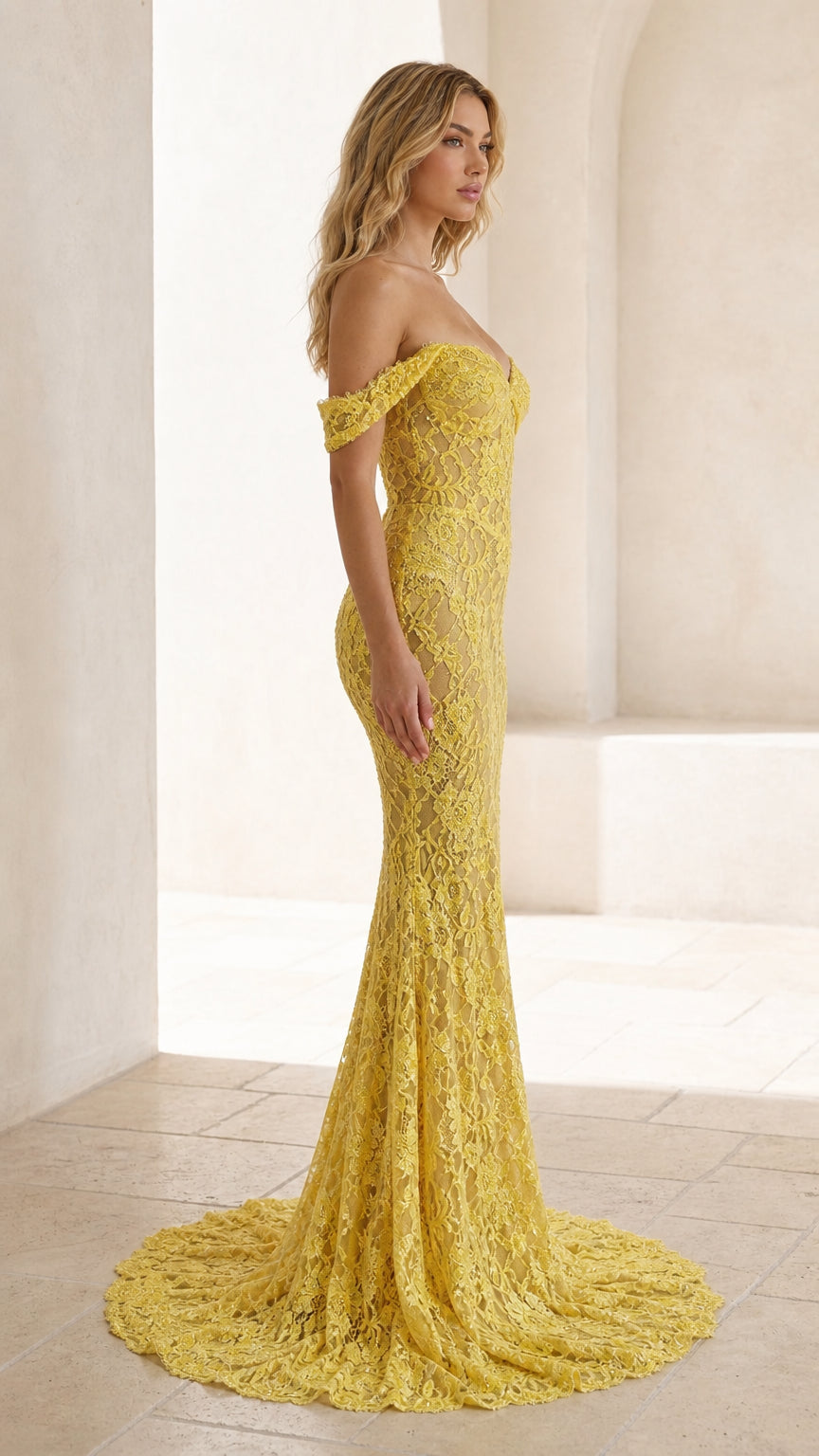 Side profile view of yellow lace evening gown with train
