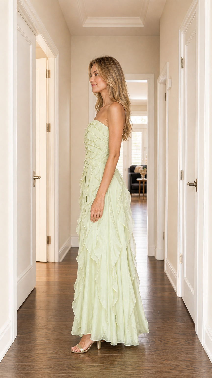 Model wearing sage green strapless ruffled maxi dress, side view