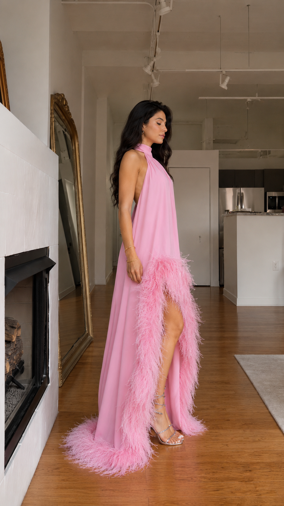 Side view of pink halter high-low dress with flowing drape and feather trim