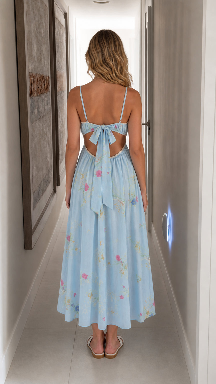 Back view showing bow tie detail on light blue floral midi dress