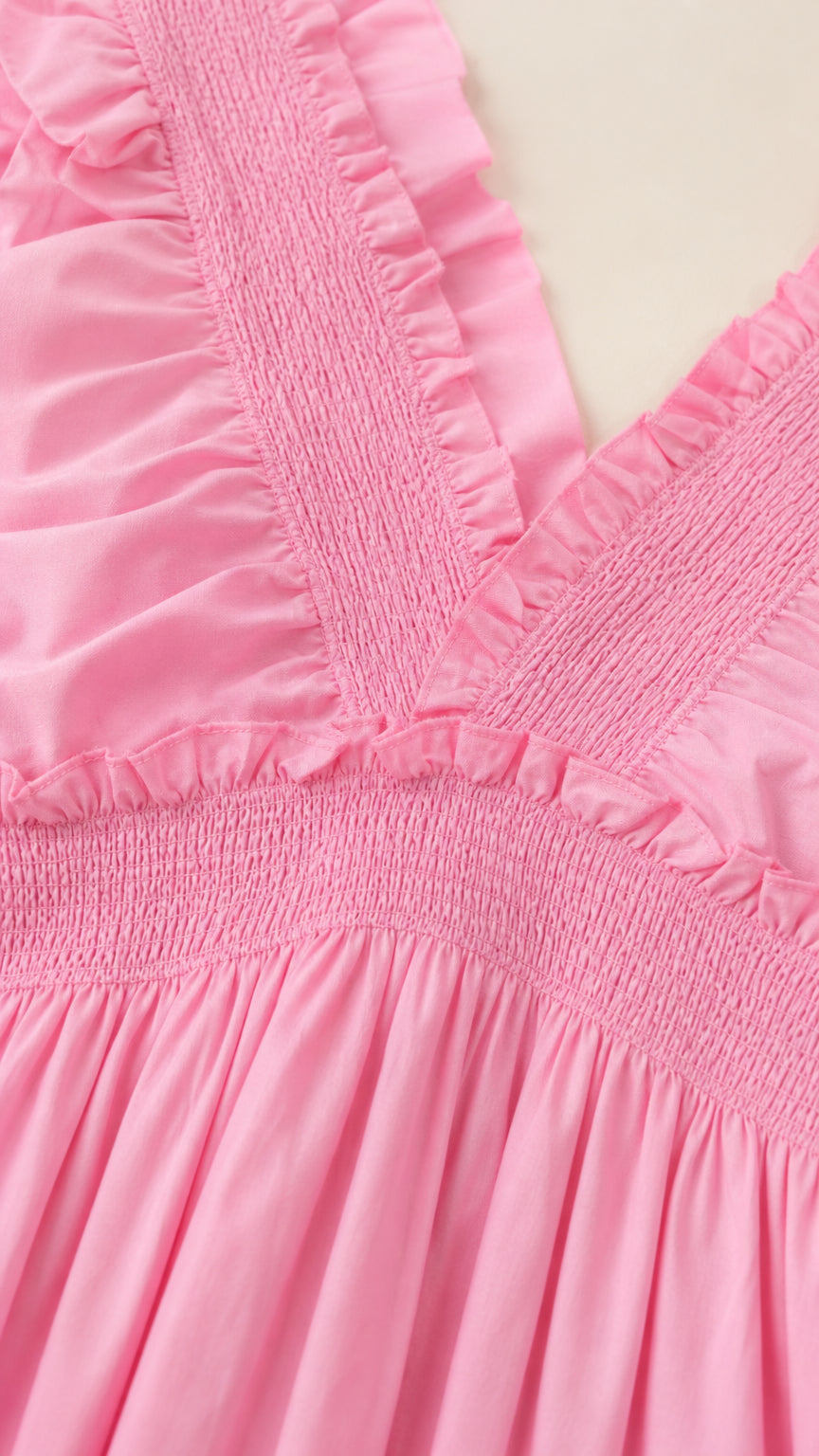 Close-up detail of smocked bodice and ruffled straps in pink