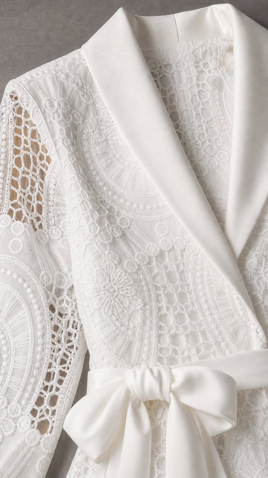 Close-up detail of white satin shawl collar and lace texture