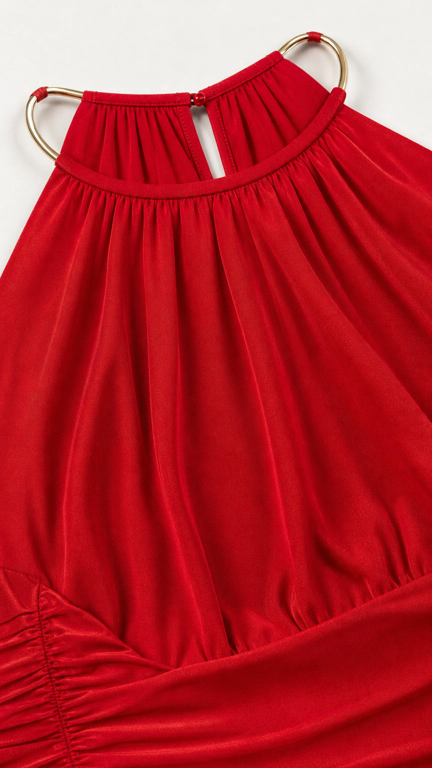 Close-up of halter neckline and metal ring detail on red dress