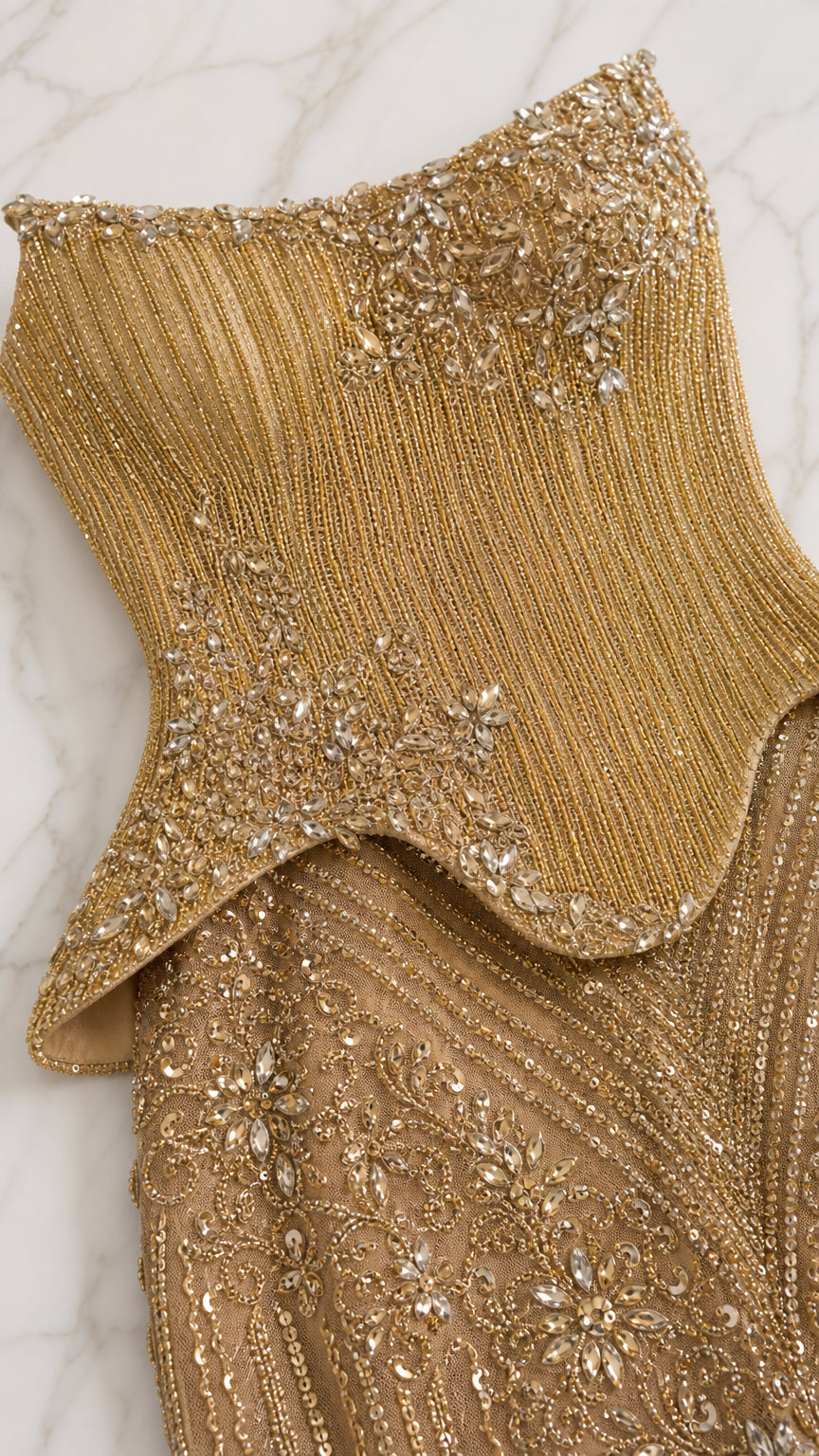 Close-up detail of crystal beadwork and peplum waist on gold gown