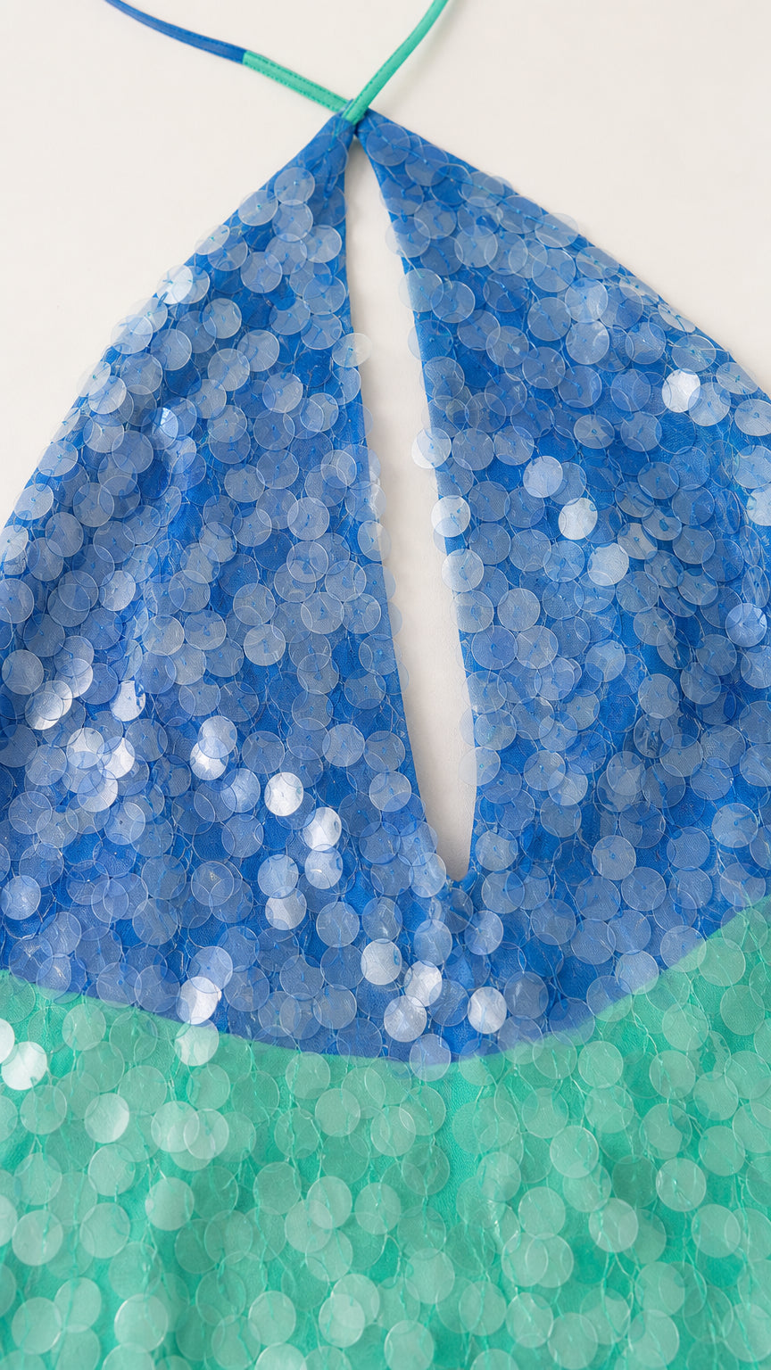 Close-up detail of blue and green sequins and keyhole neckline