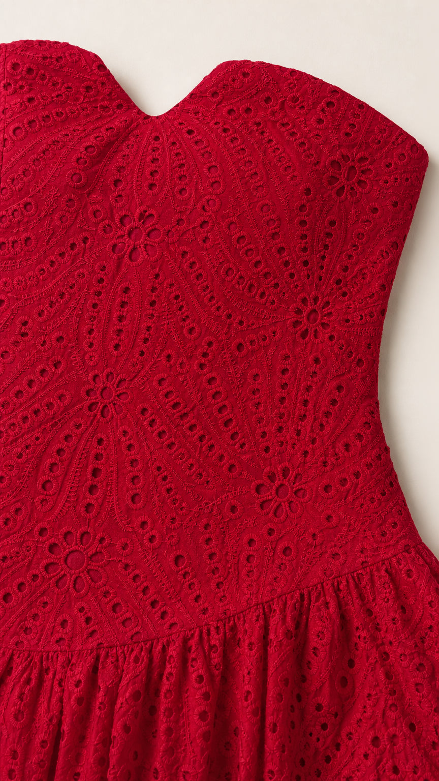 Close up of red eyelet lace fabric and bodice
