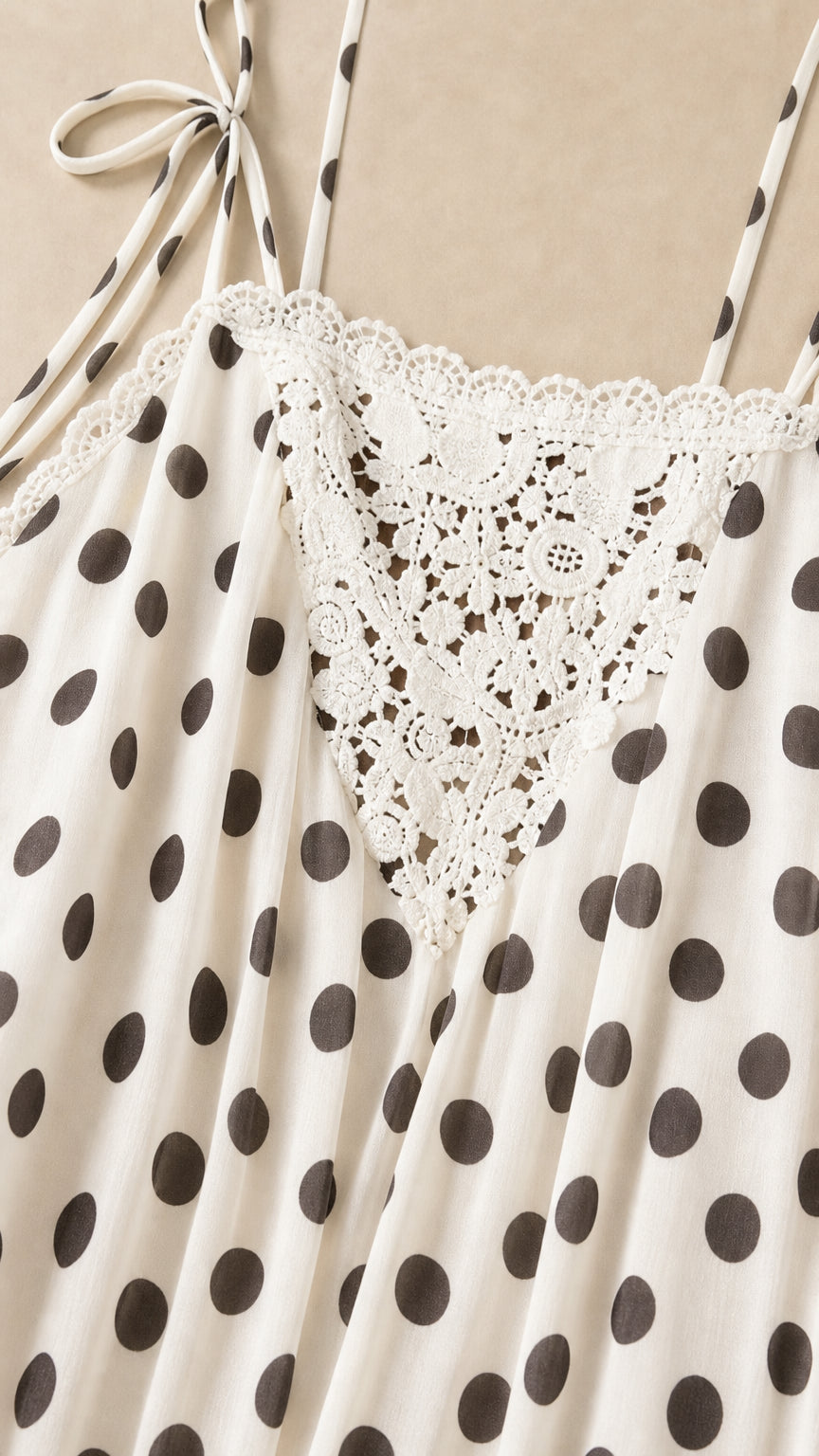 Close-up detail of lace trim and polka dot pattern on white dress