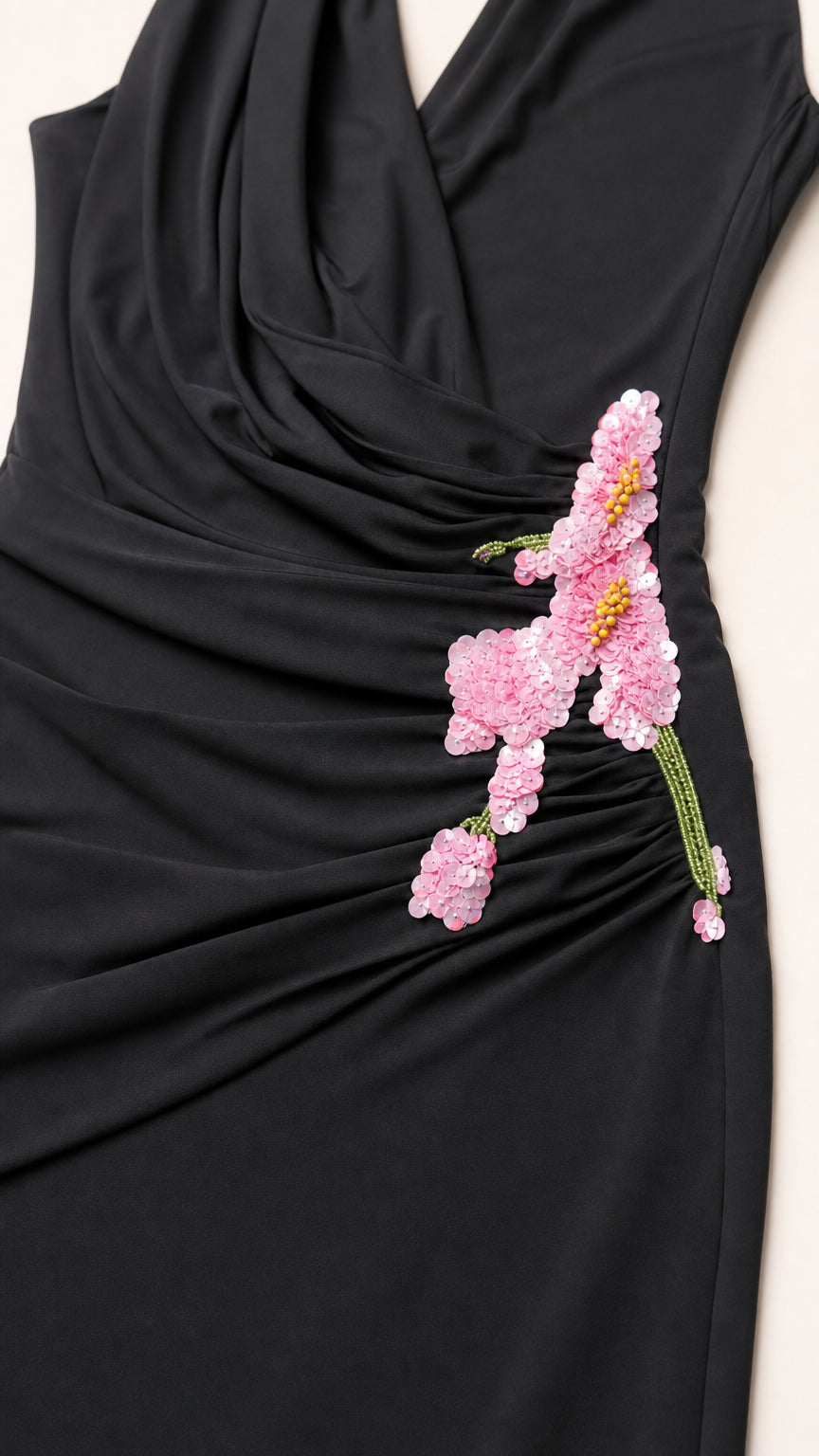Close-up detail of the floral applique and draping on black dress