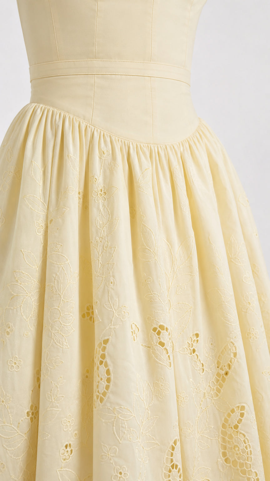 Close up detail of yellow embroidered skirt and fitted waist