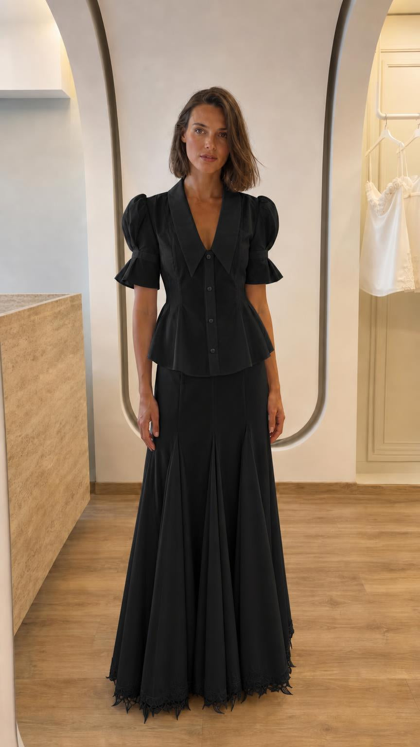Front view of woman in black two-piece peplum top and maxi skirt set