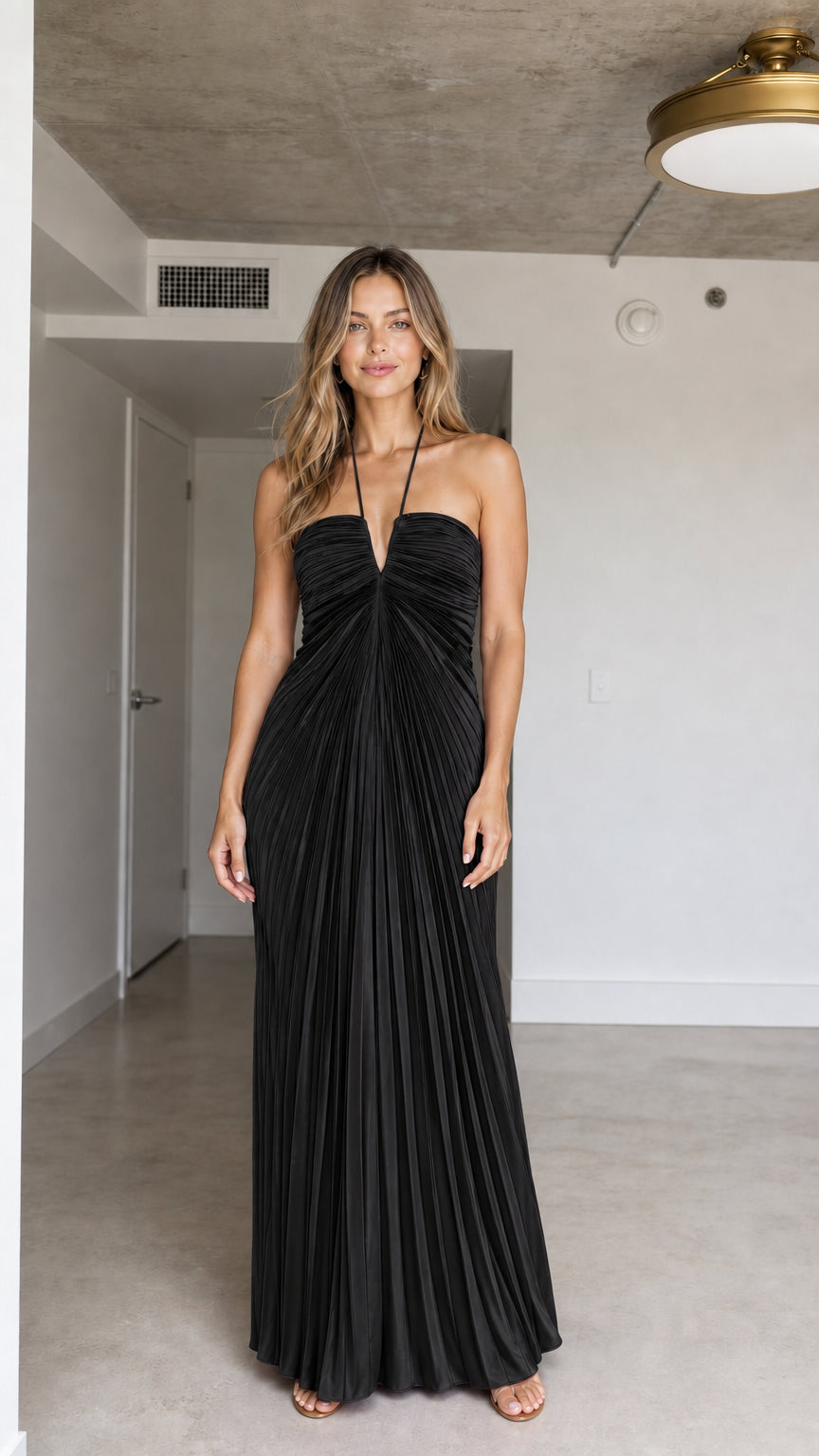 Front view of model wearing Black halter pleated maxi dress