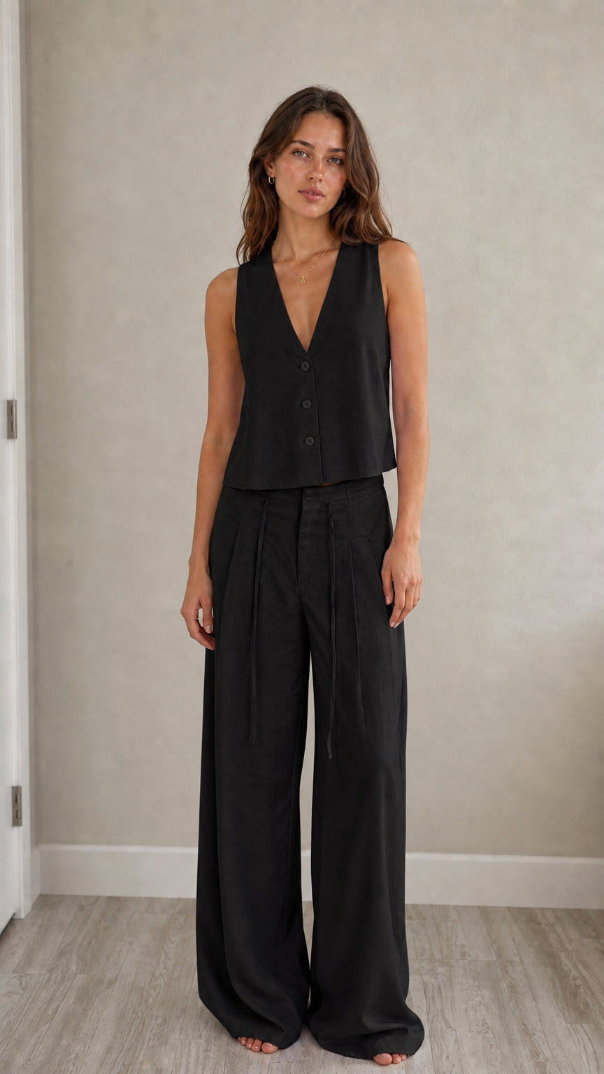 Full-length view of model in black two-piece vest and pants set