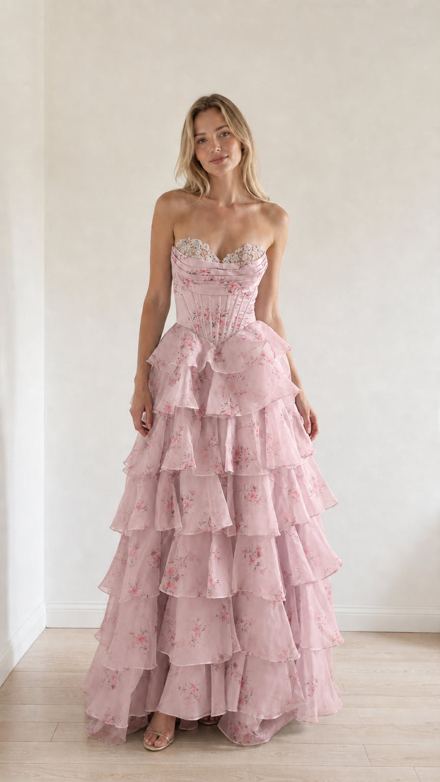 Model wearing pink floral tiered ruffle strapless evening gown