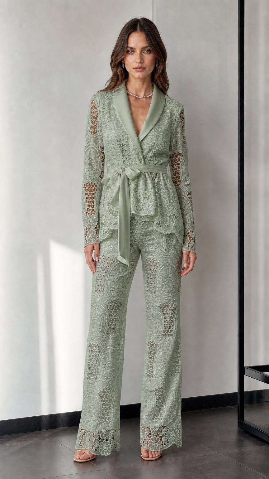 Woman wearing sage green lace blazer and trousers set