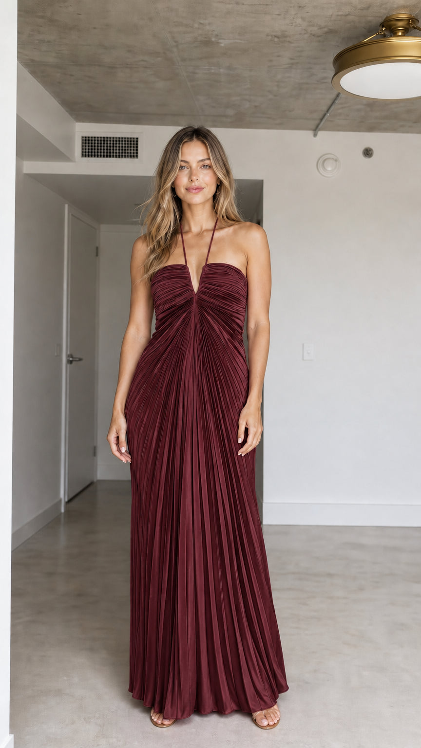 Front view of model wearing Burgundy halter pleated maxi dress