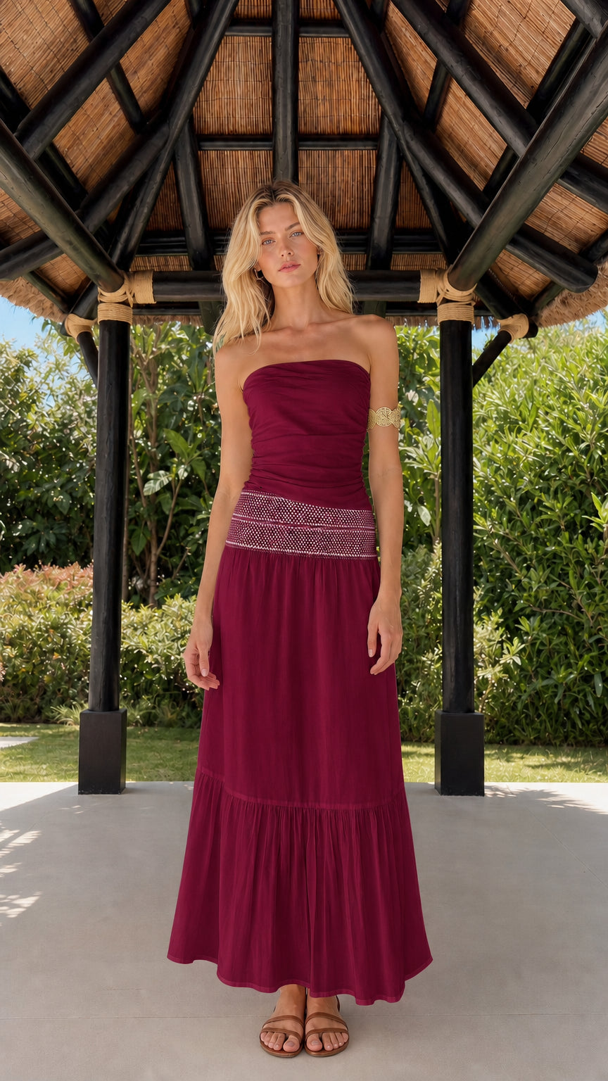 Woman wearing burgundy strapless tiered maxi dress