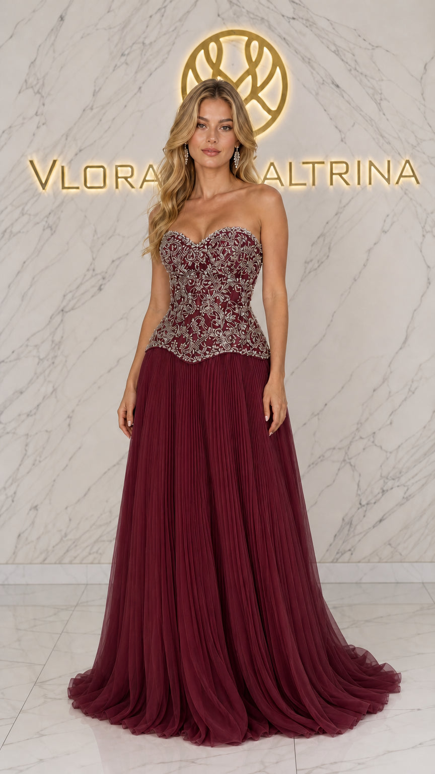 Front view of model wearing burgundy strapless embellished corset gown